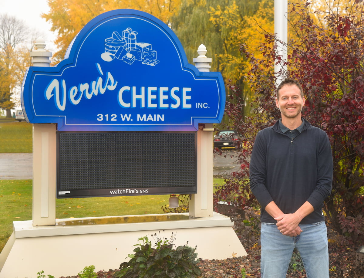 Ben Novak in front of Vern's cheese sign